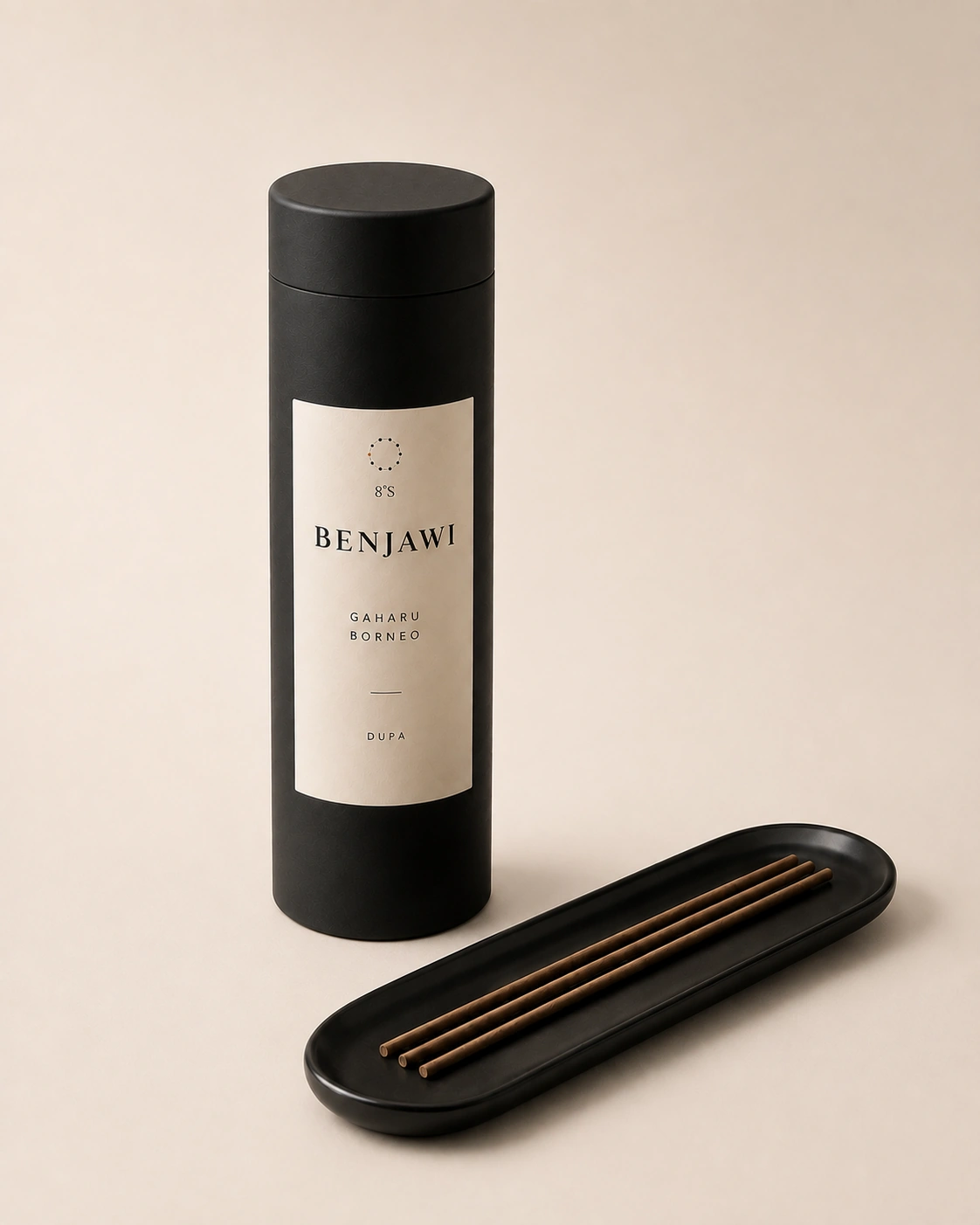 Benjawi Gaharu Borneo dupa in a round black canister beside three unlit incense sticks on a black tray