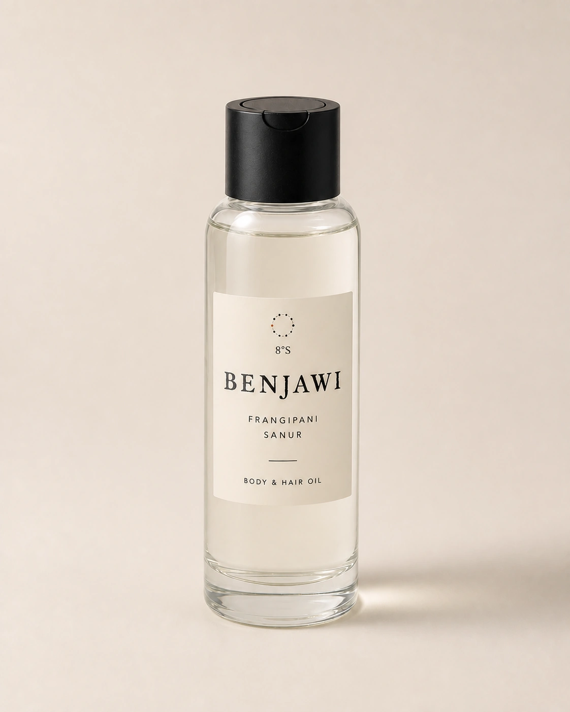 Benjawi Frangipani Sanur body and hair oil in a slender round glass bottle with a black dispensing cap