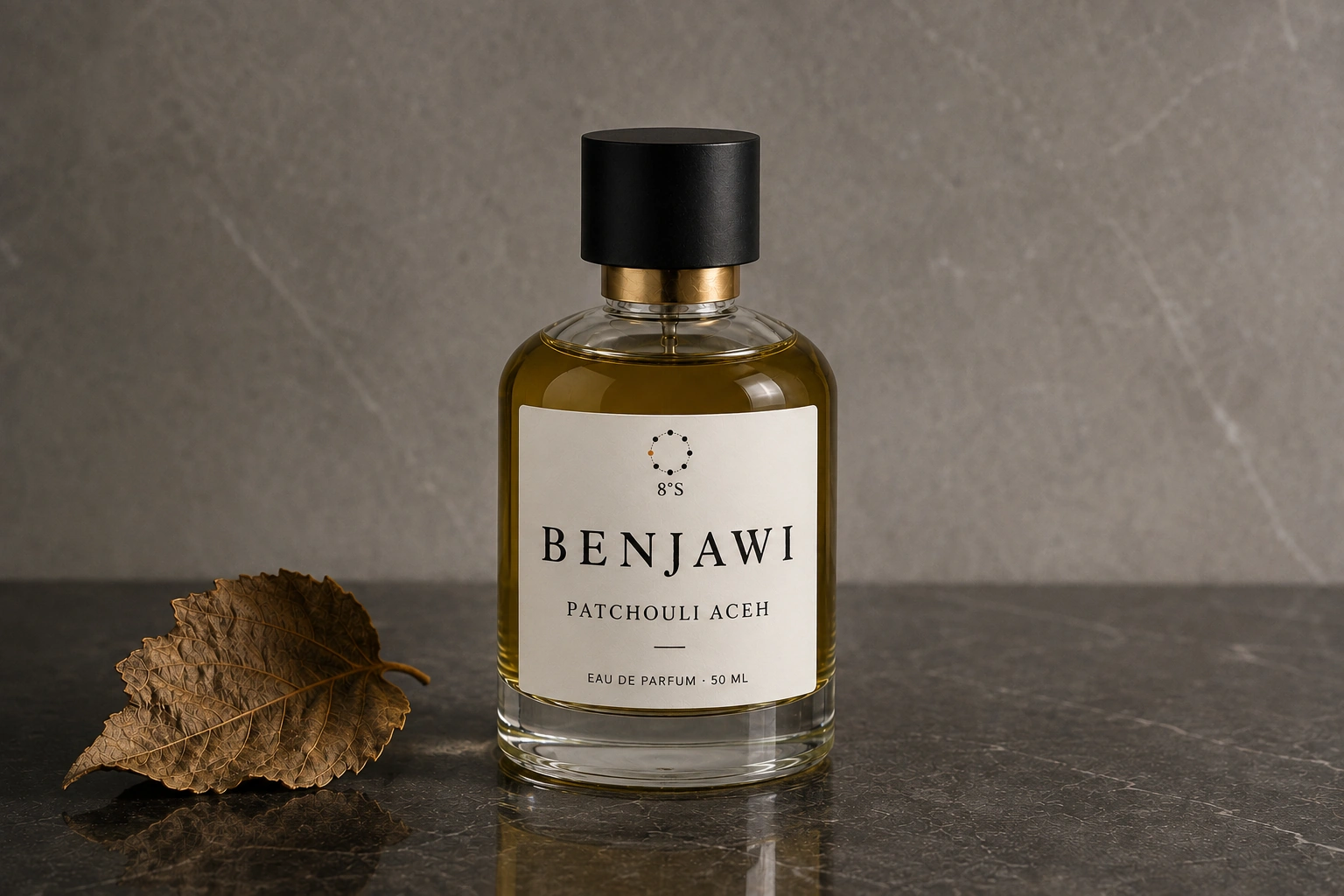 Patchouli Aceh fragrance beside one dried patchouli leaf on dark mineral stone