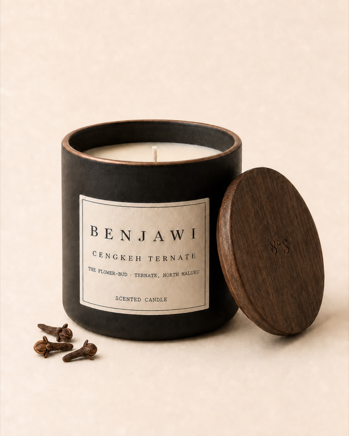 Benjawi Cengkeh Ternate scented candle beside three dried clove buds